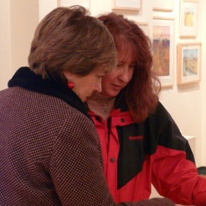 Dot and Annette look at one of Ali's books at the Orford Ness exhibition.