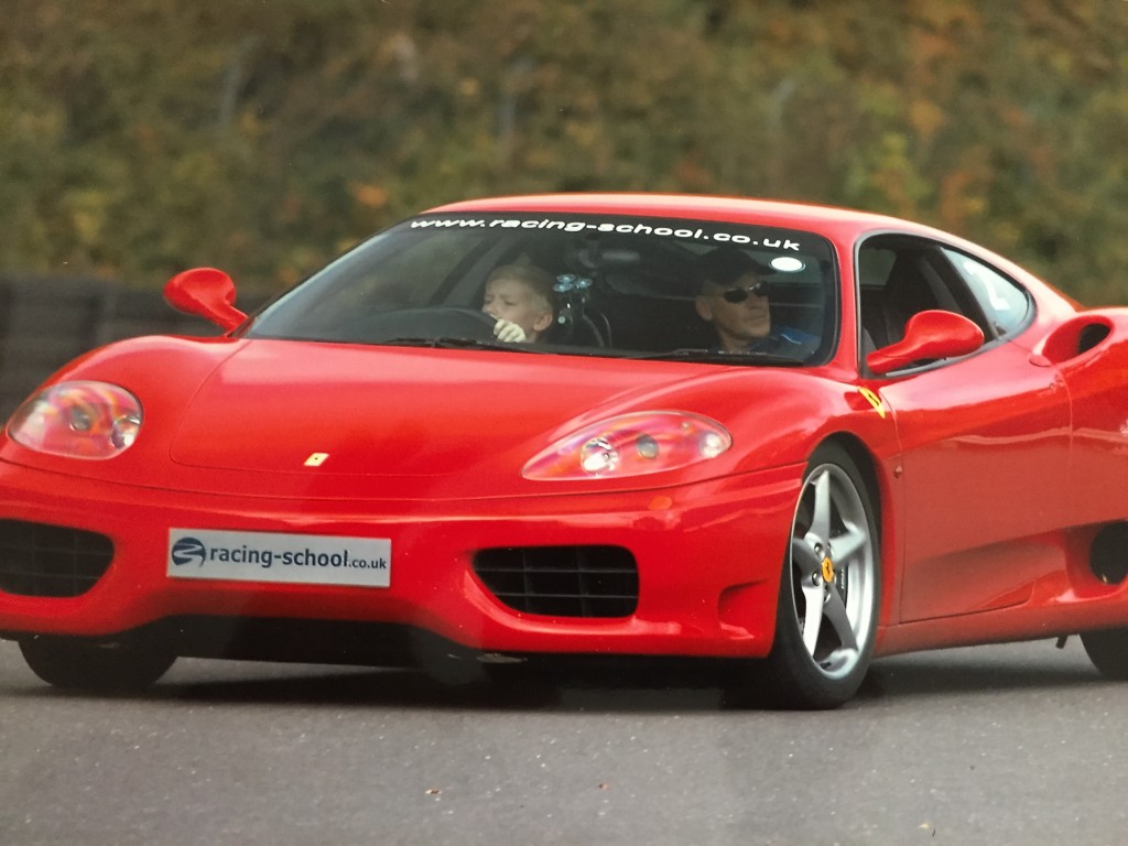 Oliver at the wheel of a fast-moving Ferrari.