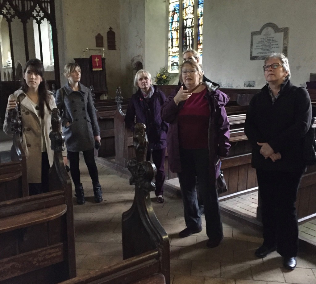 Looking at the wall paintings, prior to writing. Anna Metcalfe is obscured behind Lucy.