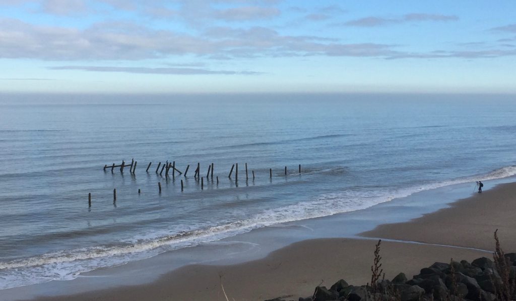 A clifftop view of Happisburgh beach on a calm late summer day.