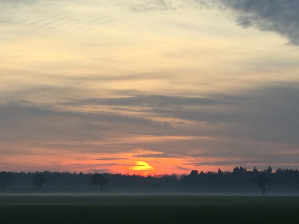 Fiery sun above afternoon mist between Saxthorpe and Norwich.